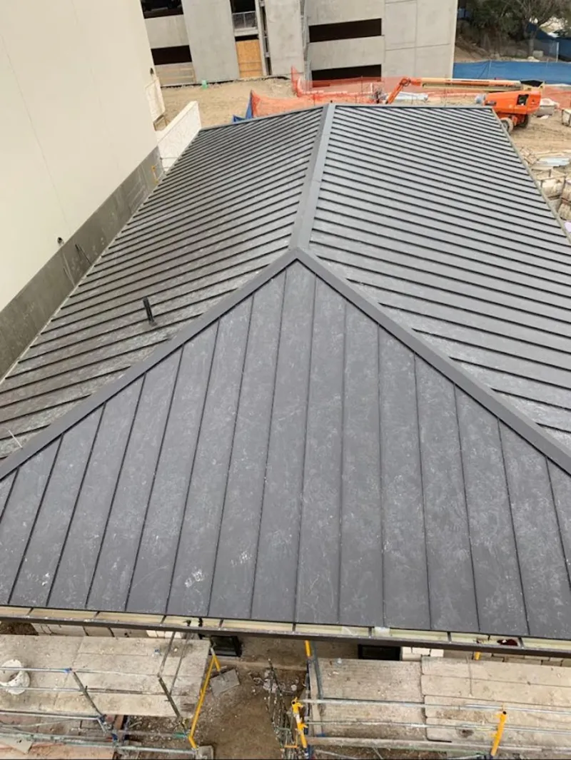 Commercial metal roof construction with crane equipment in Fairview Park